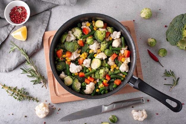 Fresh vegetables - broccoli, green beans, peas, cauliflower stewed in a saucepan, top view