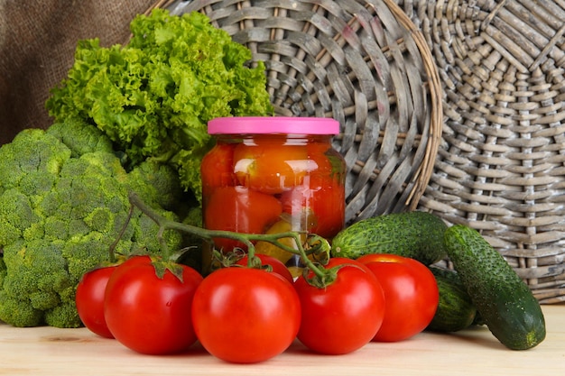 Fresh vegetables and canned on wooden table close up