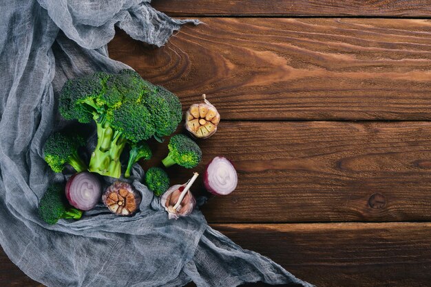 Fresh vegetables on a clay plate. On a wooden background. Top view. Free space for your text.