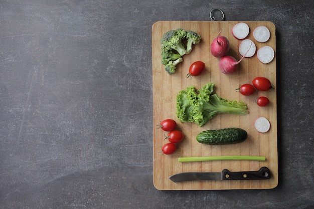 Fresh vegetables on a cutting board on a gray table