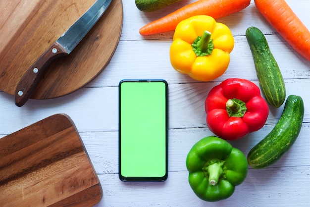 新鮮な野菜、まな板、テーブルの上のスマートフォン