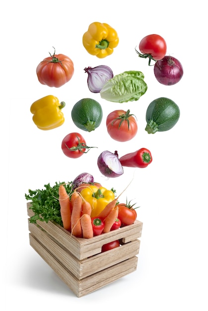 Photo fresh vegetables flying in a wooden box isolated