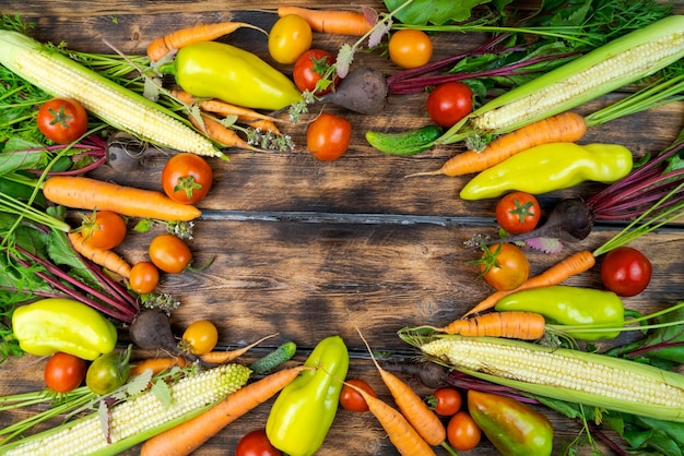 fresh vegetables from the garden beds carrots and beets tomatoes and cucumbers on an old wooden background