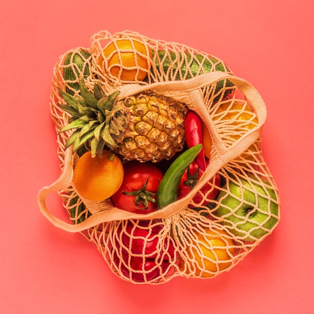 Fresh vegetables and fruits in bag mesh, top view.