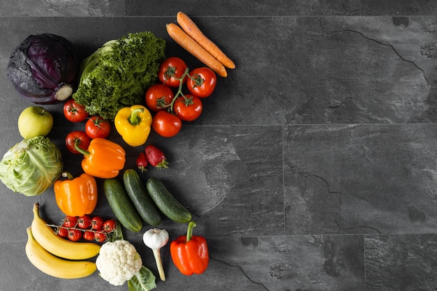Fresh vegetables and fruits on a black background Organic food Top view Free copy space