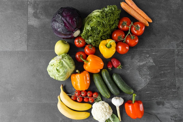 Photo fresh vegetables and fruits on a black background organic food top view free copy space