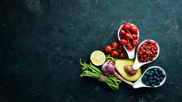 Fresh vegetables and fruits on a black background Vitamins and minerals Top view Free space for your text