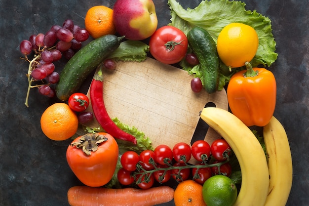 黒の背景に新鮮な野菜や果物。ビタミンとミネラル。上面図。あなたのテキストのためのスペースを作ってください。