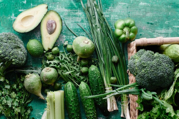 Fresh vegetables and fruits and greens on a shabby green background. Healthy eating concept