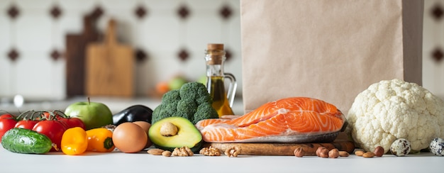 Fresh vegetables, fruits, nuts and salmon steak.