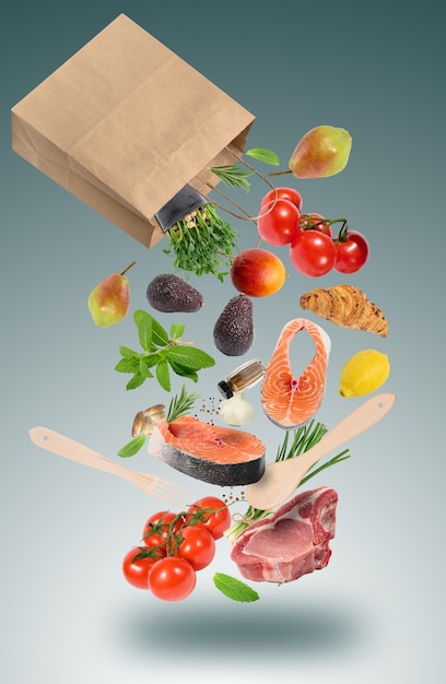 Свежие овощи, фрукты, стейки из лосося и свинина на кости со специями падают из коричневой бумажной сумки Покупка продуктов в супермаркете