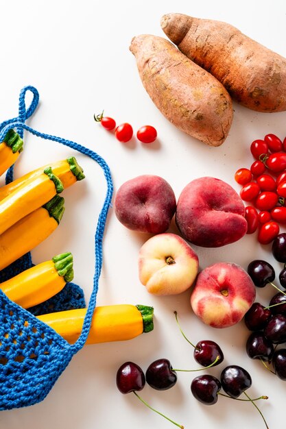 Foto verdure e frutta fresche in una borsa per lo shopping su un tavolo bianco acquistati in un supermercato