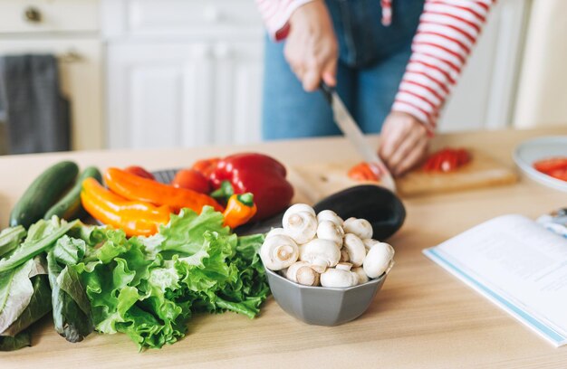 Photo fresh vegetables green salad peppers mushrooms and eggplant on kitchen table