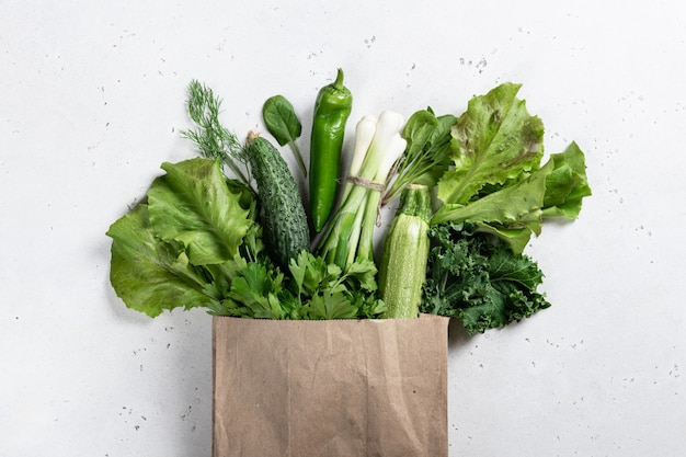 Fresh vegetables and greens in a paper bag