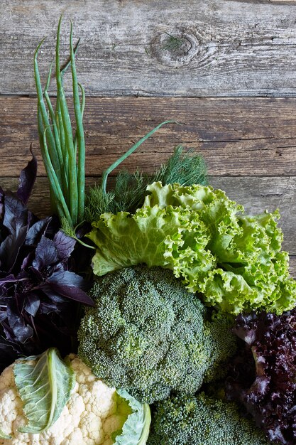 Fresh vegetables and herbs on an old rough wooden surface, healthy eating concept, selective focus