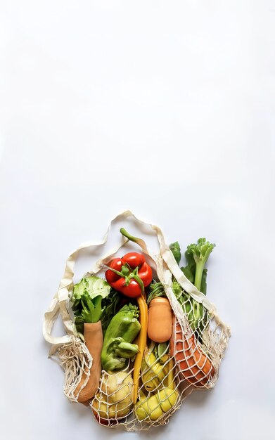 Фото Свежие овощи в тканевом мешке на белом фоне