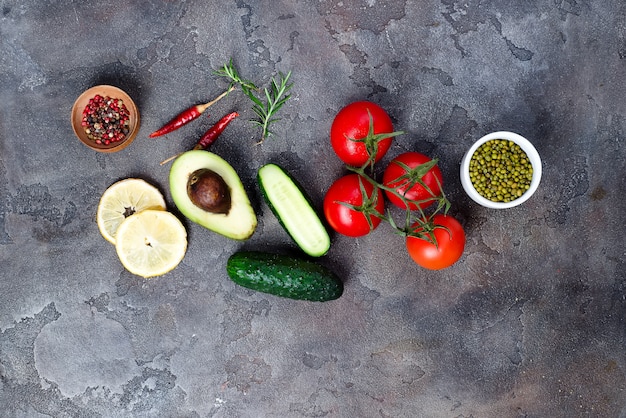 Fresh vegetables ingredients for salad with mung beans on stone background, top view,