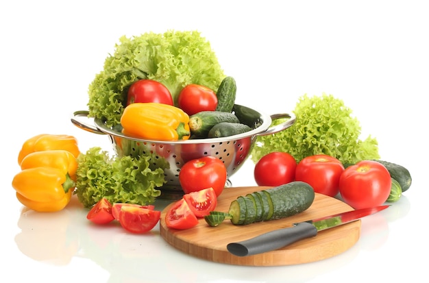 Fresh vegetables and knife on cutting board isolated on white