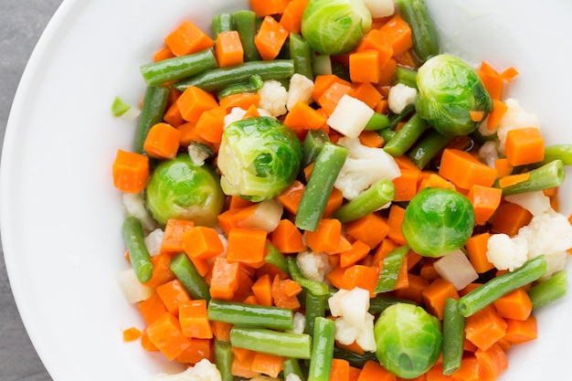 Fresh vegetables mix in a white bowl.