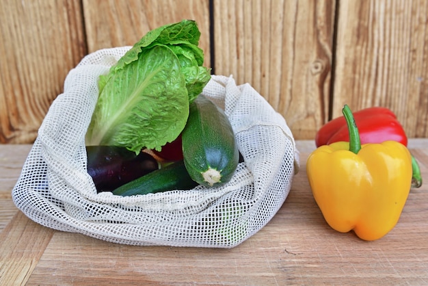 Fresh vegetables in a reusable bag put on a wooden table