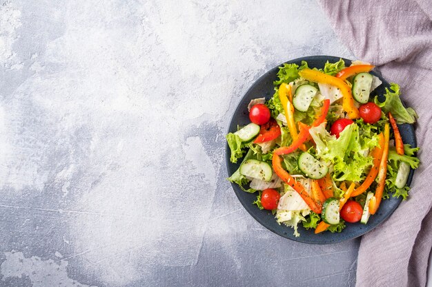 Fresh vegetables salad on a plate. Top view, copy space