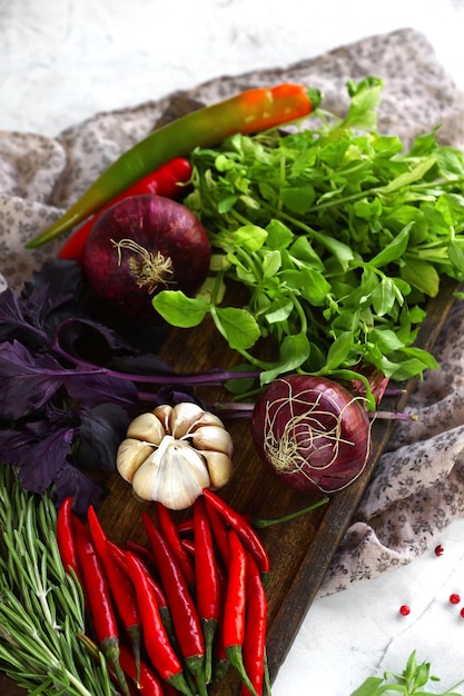 Fresh vegetables spices and herbs red pepper onions garlic basil in wooden box in rustic style