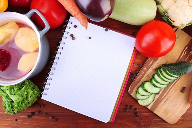 Foto verdure fresche e spezie e carta per appunti, su legno