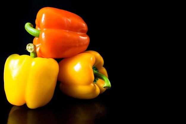 Fresh vegetables Three sweet peppers on a black background