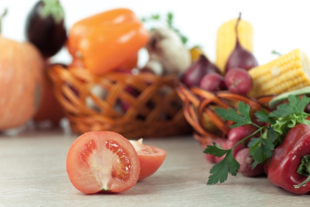 Fresh vegetables in wicker baskets on the wooden table