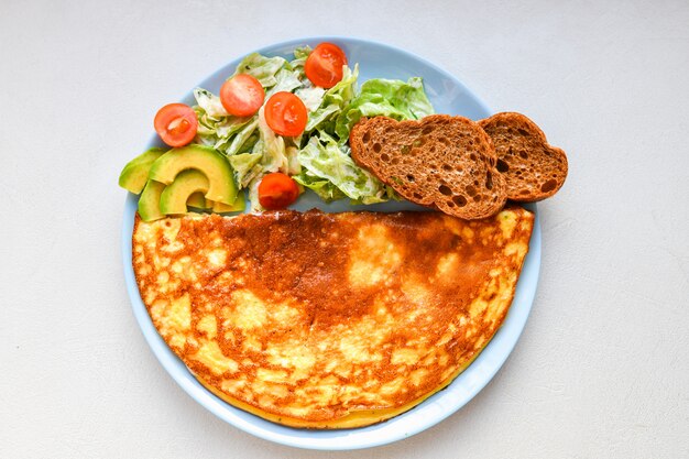 Fresh vegetables with scrambled eggs. on a round plate. Omelet with mushrooms