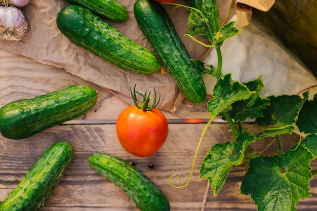 Fresh vegetables on a wooden background The concept of healthy eating Cucumbers tomatoes garlic dill Top view