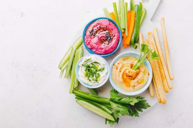 Fresh vegetarian dips in small bowls on table