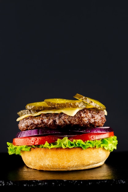 Fresh vegetarian tasty burger on a black background. Making a burguer in stages