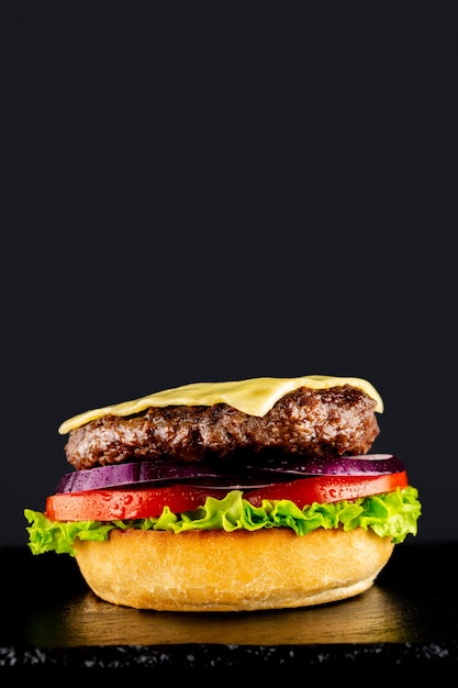 Fresh vegetarian tasty burger on a black background. Making a burguer in stages