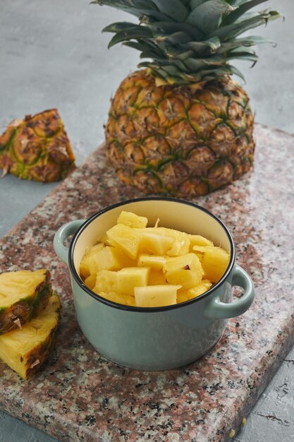 Foto pezzi di ananas freschi e vivaci su una base grigia per una dieta sana e disintossicante
