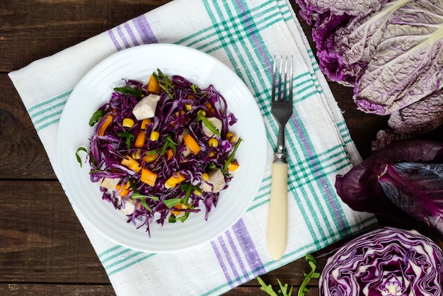 Fresh vitamin fitness salad of red cabbage, bell peppers, corn, arugula. Vegan diets. The top view