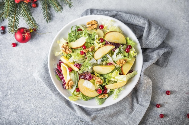 Fresh Waldorf salad with lettuce, green apples, walnuts and celery on wooden table. Top view.Copy space