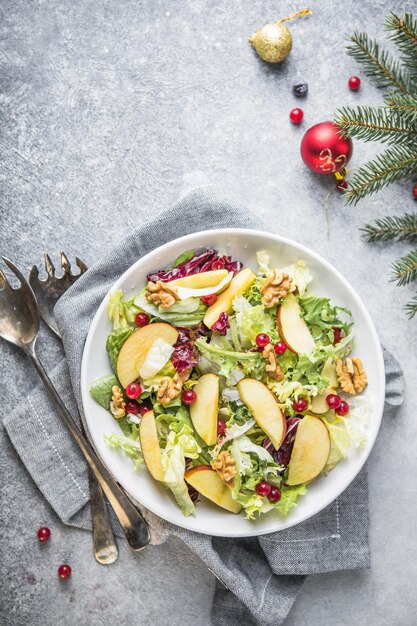 Fresh waldorf salad with lettuce, green apples, walnuts and celery on wooden table. top view.copy space