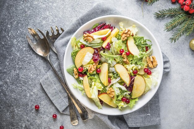 Fresh Waldorf salad with lettuce, green apples, walnuts and celery on wooden table. Top view.Copy space