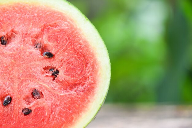 Fetta di anguria fresca a metà sul verde della natura primo piano di frutta tropicale anguria sul tavolo