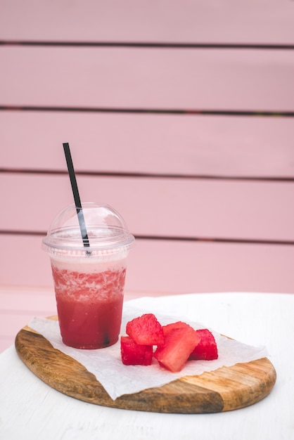 Fresh watermelon smoothie. vegetarian treat for the whole family. Closed glass with black straw