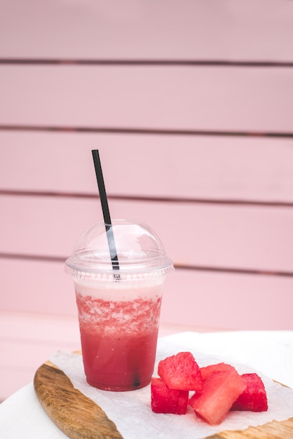 Fresh watermelon smoothie. vegetarian treat for the whole\
family. closed glass with black straw