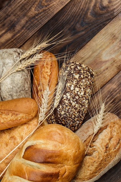 Fresh white and black bread on a wooden table