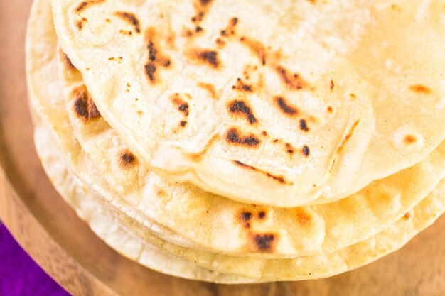 Fresh white corn tortillas on the plate.