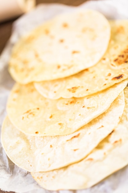 Fresh white corn tortillas on a white paper.