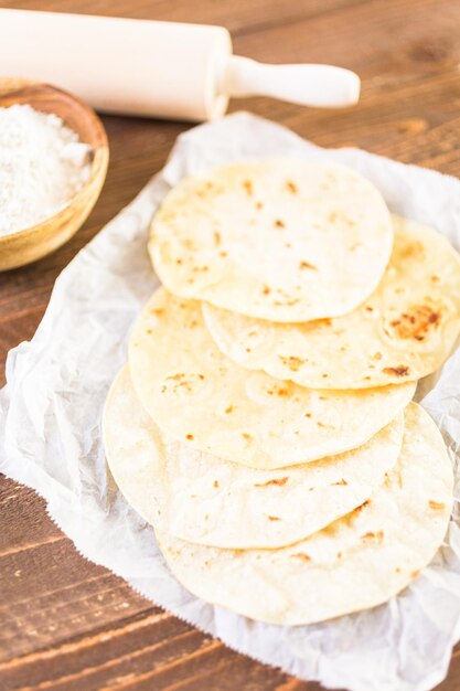 Fresh white corn tortillas on a white paper.