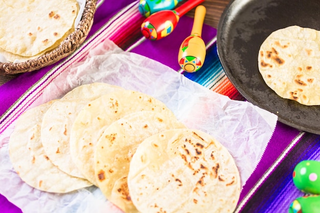 Fresh white corn tortillas on a white paper.