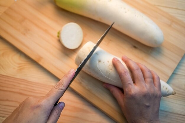 Fresh white daikon radish with slice on the wooden background Hand cut Korean radishes