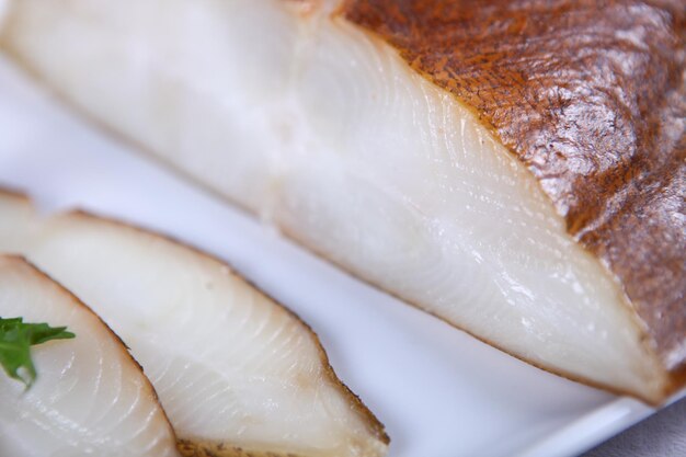 Fresh white fish decorated with salad and condiment. Close-up