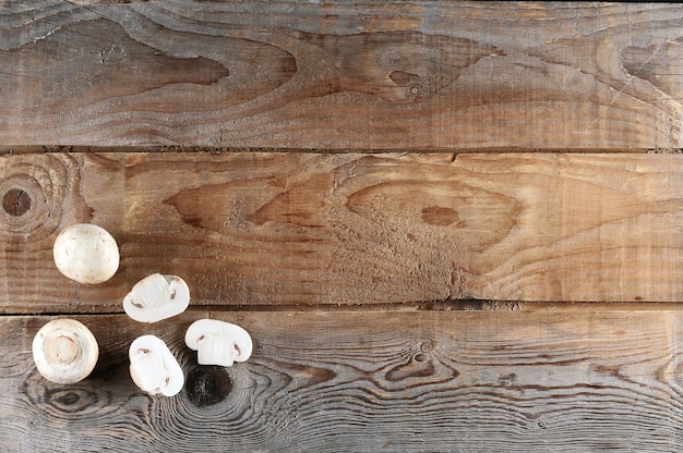 Fresh white mushrooms champignon on rustic wooden  